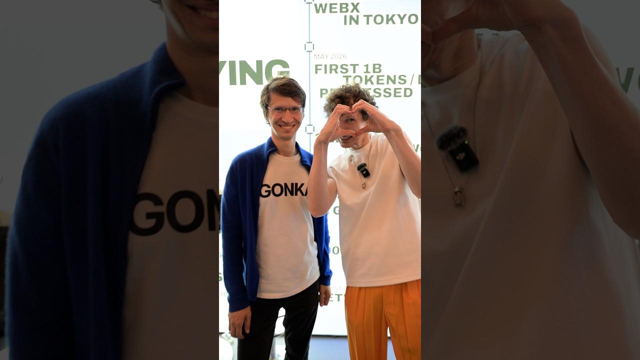 Two Gonka team members, one making a heart with their hands, at the WebX 2026 booth in Tokyo
